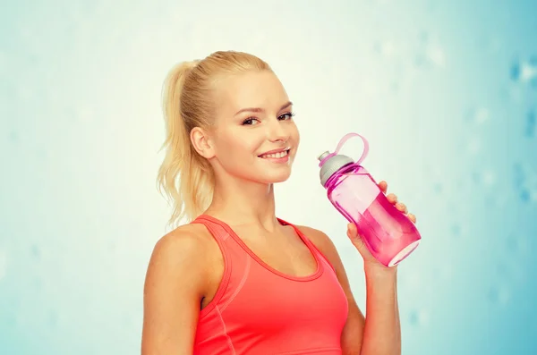 Mujer deportiva sonriente con botella de agua —  Fotos de Stock