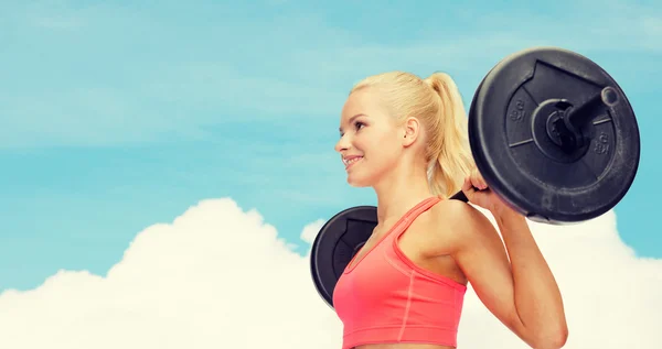 Sorrindo mulher desportiva exercitando com barbell — Fotografia de Stock
