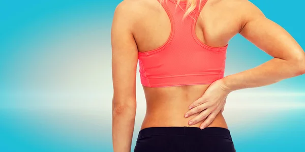 Close up of sporty woman touching her back — Stock Photo, Image