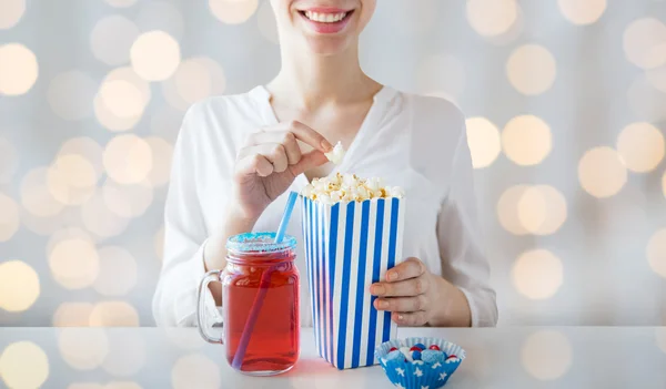 Mujer comiendo palomitas de maíz con bebida en tarro de cristal de albañil — Foto de Stock