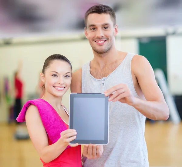 Duas pessoas sorrindo mostrando tela de tablet pc em branco — Fotografia de Stock