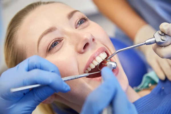 Närbild på tandläkare behandla kvinnlig patient tänder — Stockfoto