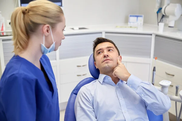 Dentista masculino con paciente mujer en la clínica —  Fotos de Stock