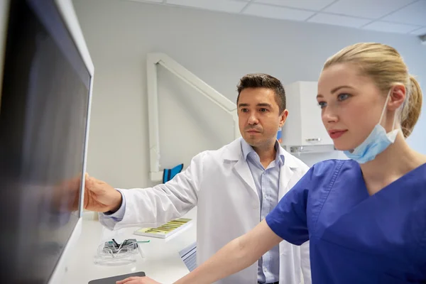 Dentists with x-ray on monitor at dental clinic — Stock Photo, Image