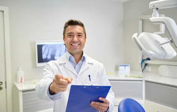 Happy dentist pointing to you at dental clinic — Stock Photo, Image