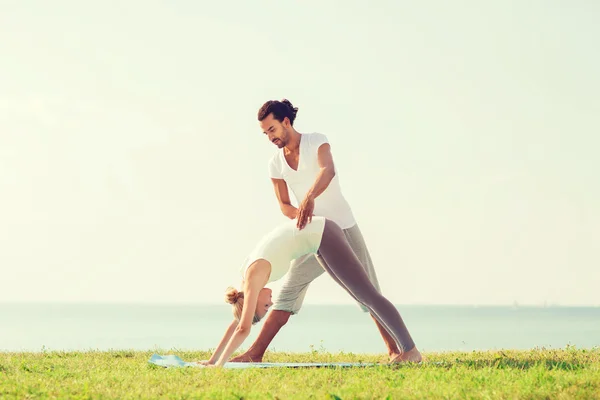 Çift gülümseyen açık havada yapım yoga egzersizleri — Stok fotoğraf