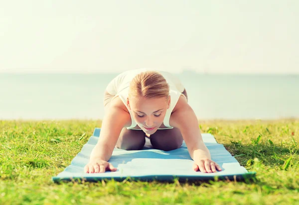 Ung kvinna att göra yogaövningar utomhus — Stockfoto