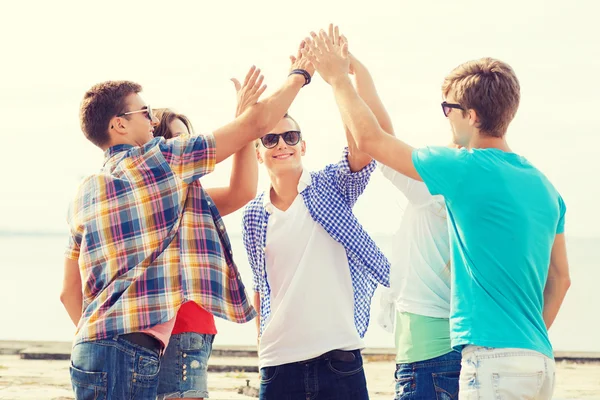 Groep lachende vrienden maken hoge vijf buitenshuis — Stockfoto