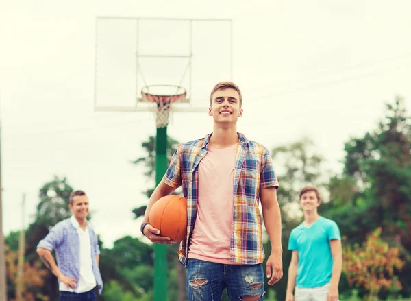 Groep van lachende tieners spelen basketbal — Stockfoto