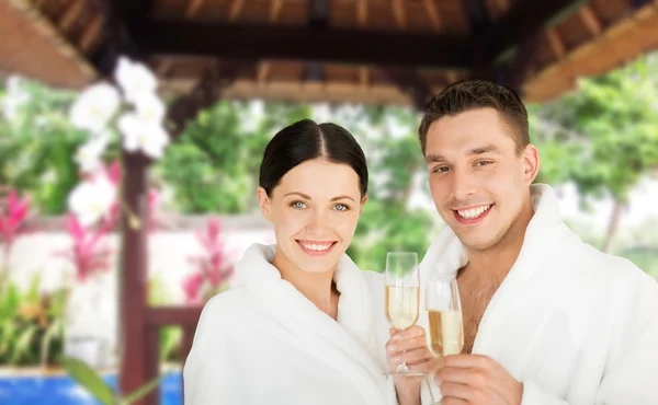 Happy couple in bathrobes with champagne at resort — Stock Photo, Image