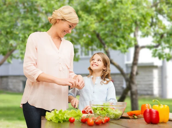 Happy family cooking vegetable salad for dinner — Stock Photo, Image