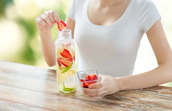 Menutup wanita dengan air buah dalam botol kaca — Stok Gambar Menutup wanita dengan air buah dalam botol kaca Stok Foto
