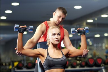 man and woman with dumbbells in gym clipart