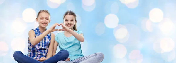 Gelukkig weinig meisjes weergegeven: hart vorm hand teken — Stockfoto