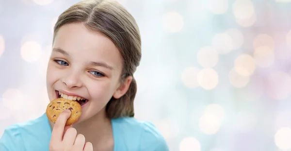 クッキーまたはビスケットを食べる少女の笑みを浮かべてください。 — ストック写真