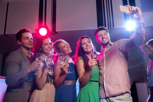 Friends with glasses and smartphone in club — Stock Photo, Image