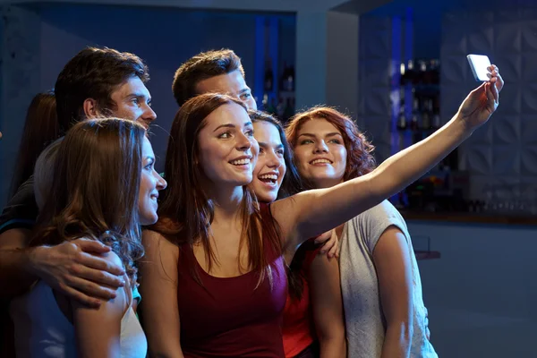 Друзі зі смартфоном беруть селфі в клуб — стокове фото