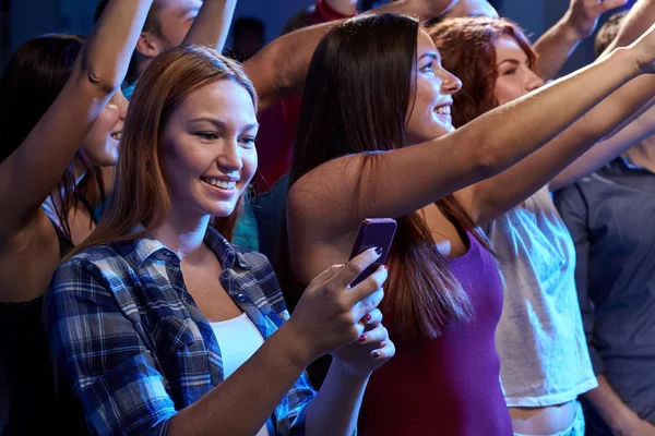 Woman with smartphone texting message at concert — Stock Photo, Image