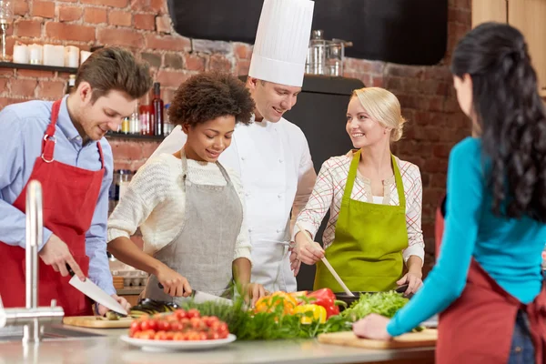 Amigos felices y cocinero cocinar en la cocina — Foto de Stock