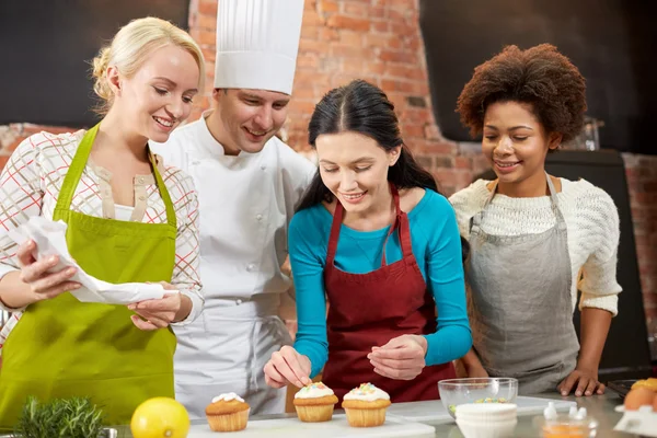 Mujeres felices y cocinero hornear en la cocina —  Fotos de Stock