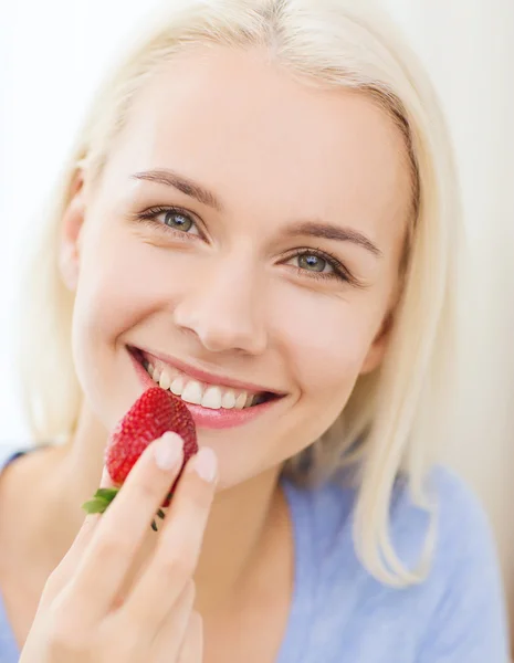 Mulher feliz comendo morango em casa — Fotografia de Stock