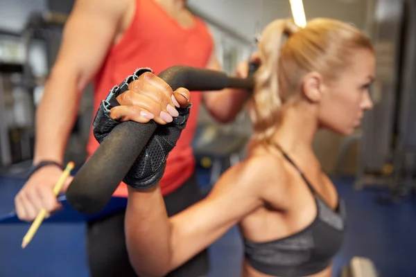 Hombres y mujeres flexionando los músculos en la máquina de gimnasio —  Fotos de Stock