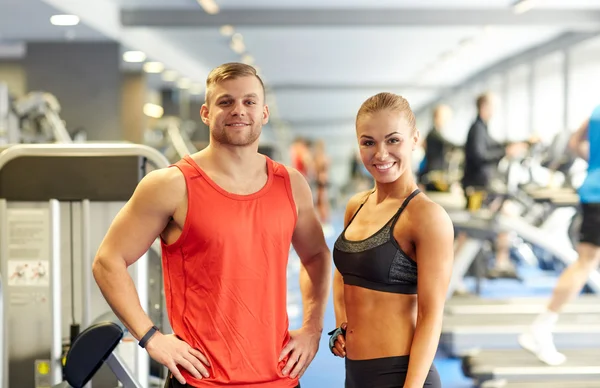 Homme et femme souriants dans la salle de gym — Photo