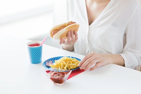 Primer plano de la mujer comiendo perrito caliente y papas fritas —  Fotos de Stock