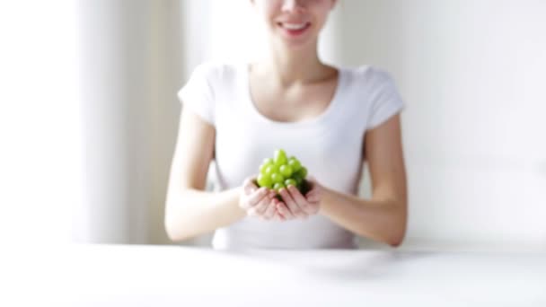 Primo piano di giovane donna che mostra grappolo di uva verde — Video Stock