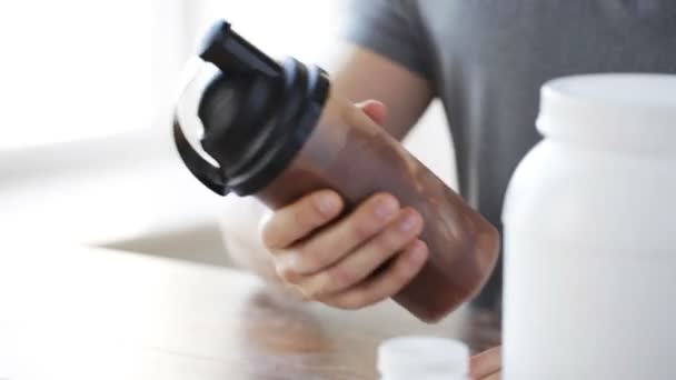 Close up of man with protein shake bottle and jar — Stock Video