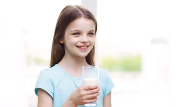 Feliz sonriente niña bebiendo leche en casa — Vídeos de Stock