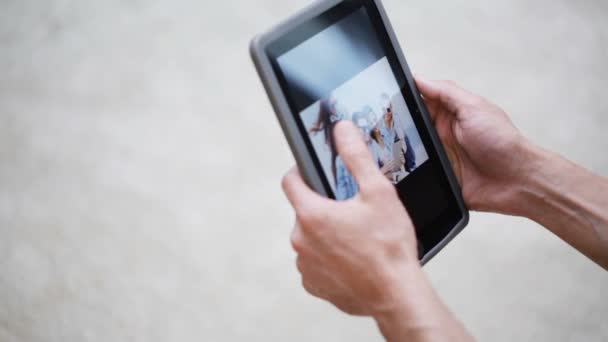 Mãos de casal com tablet pc visualização de fotos em casa — Vídeo de Stock