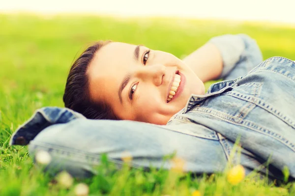 Souriant jeune fille couchée sur l'herbe — Photo