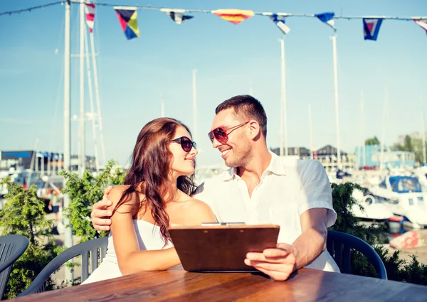 Casal sorrindo com menu no café — Fotografia de Stock