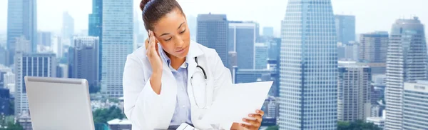 Kvinnliga läkare med laptop läsa medicinsk rapport — Stockfoto