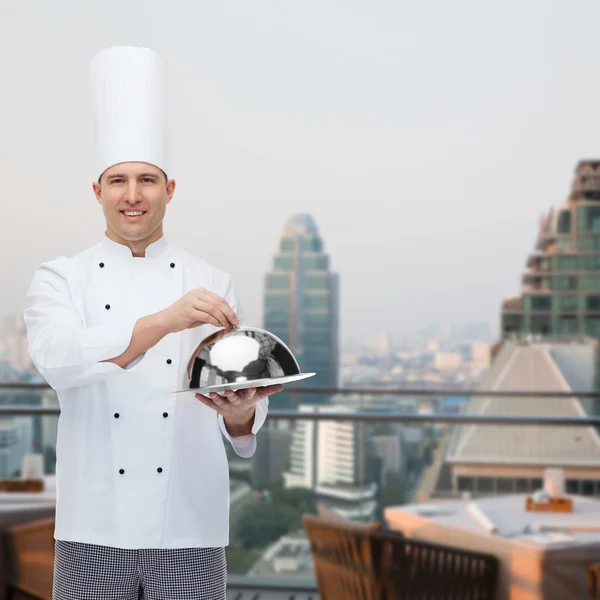 Šťastný muž kuchař kuchař drží cloche — Stock fotografie