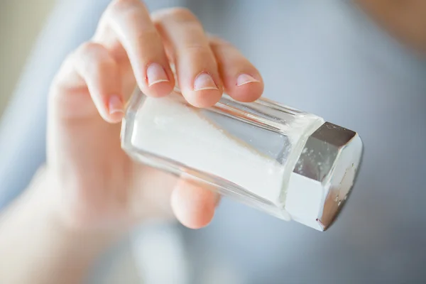 Fechar a mão segurando adega de sal branco — Fotografia de Stock