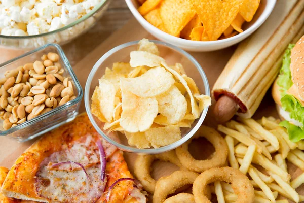 Close up of fast food snacks and drink on table — Stock Photo, Image