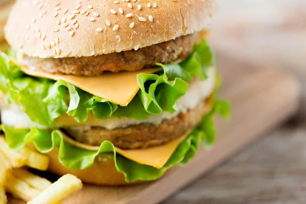 Primer plano de hamburguesa o hamburguesa con queso en la mesa —  Fotos de Stock