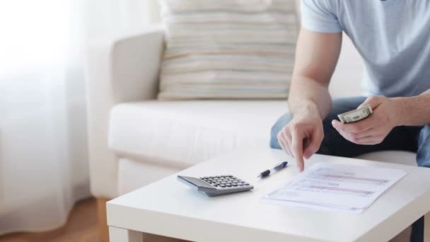 Nahaufnahme eines Mannes mit Taschenrechner, der Geld zählt — Stockvideo