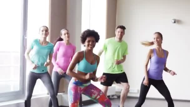 Groupe de personnes souriantes dansant en salle de gym ou studio — Video