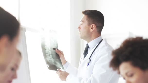 Врач с рентгеном и группой медиков в больнице — стоковое видео