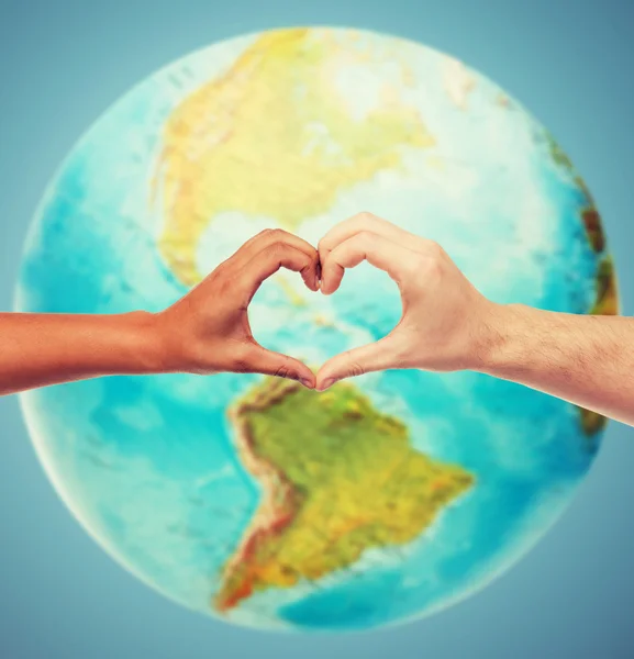 Manos humanas mostrando la forma del corazón sobre el globo terrestre — Foto de Stock