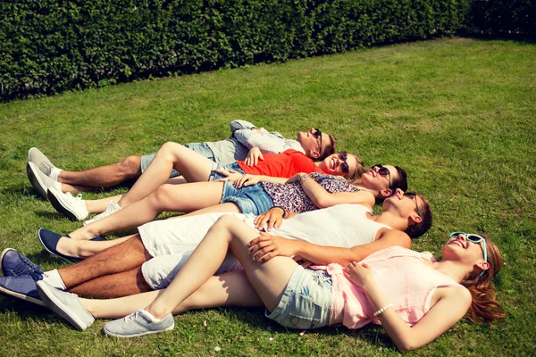 Група усміхнених друзів, що лежать на траві на відкритому повітрі — стокове фото