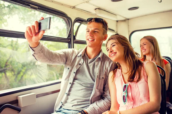 Smiling couple with smartphone making selfie — Stock Photo, Image