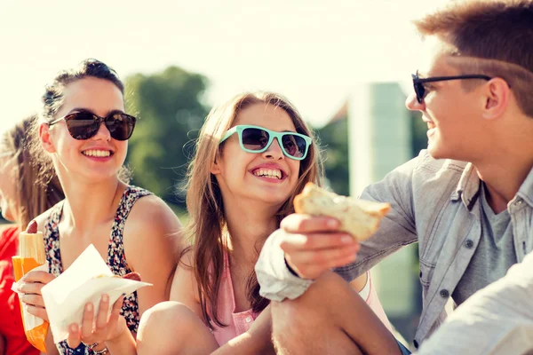 Gruppo di amici sorridenti seduti sulla piazza della città — Foto Stock