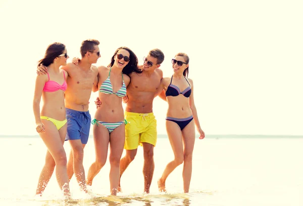 Lachende vrienden in zonnebril op zomer strand — Stockfoto