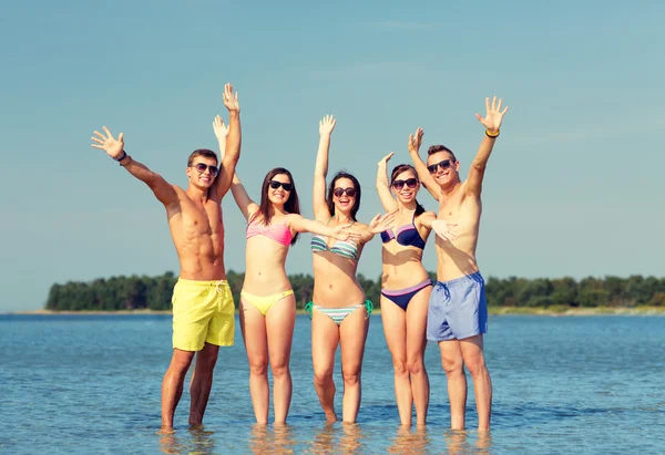 Smiling friends in sunglasses on summer beach — Stock Photo, Image