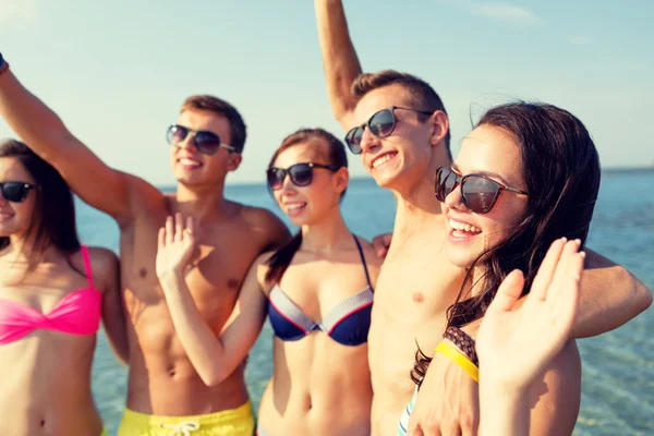 Amici sorridenti in occhiali da sole sulla spiaggia estiva — Foto Stock