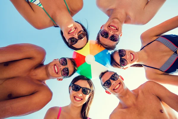 Amici sorridenti in cerchio sulla spiaggia estiva — Foto Stock